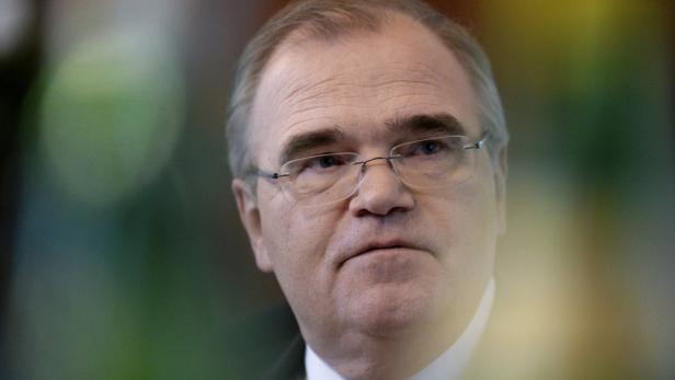 Ein Mann mit Brille blickt nachdenklich zur Seite.