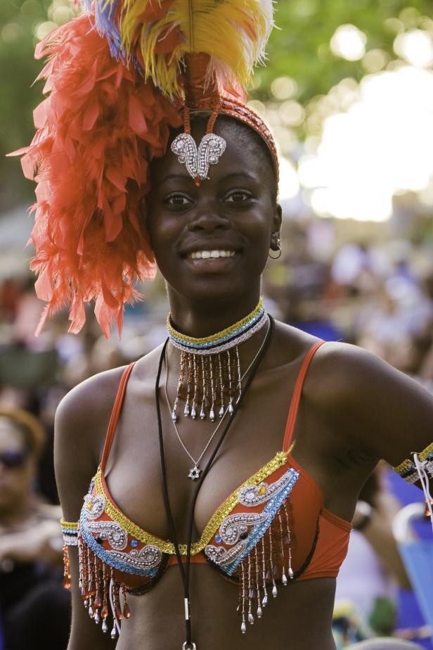 Eine Frau mit einem farbenprächtigen Karnevalskostüm lächelt in die Kamera.