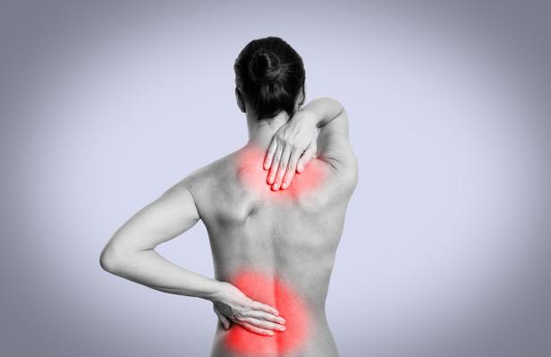 Eine Frau hat Schmerzen im Rücken und in der Schulter.