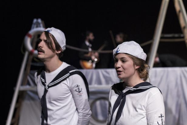 Zwei Schauspieler in Matrosenkostümen stehen auf einer Bühne.