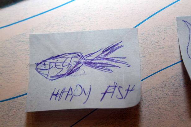 Eine Kinderzeichnung zeigt einen Fisch mit der Aufschrift „Happy Fish“.