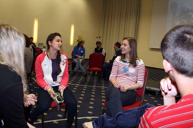 Mehrere Personen sitzen in einem Raum und unterhalten sich.