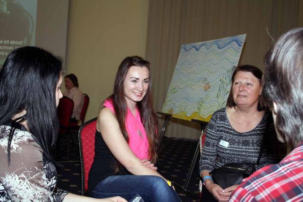 Drei Frauen sitzen in einem Raum und unterhalten sich.