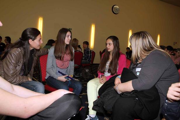 Eine Gruppe junger Frauen sitzt in einem Raum und unterhält sich.