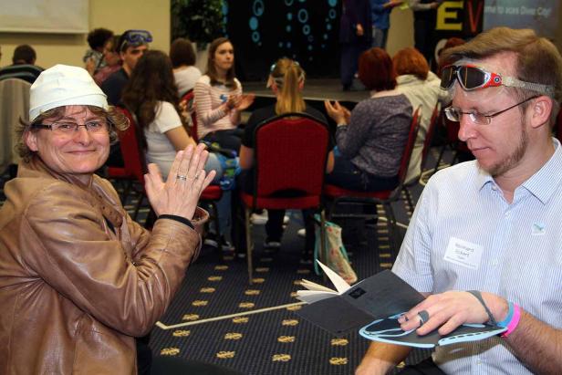 Zwei Personen im Publikum applaudieren bei einer Veranstaltung zum Thema Tauchen.