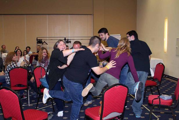 Eine Gruppe von Menschen spielt ein energiegeladenes Spiel in einem Konferenzraum.