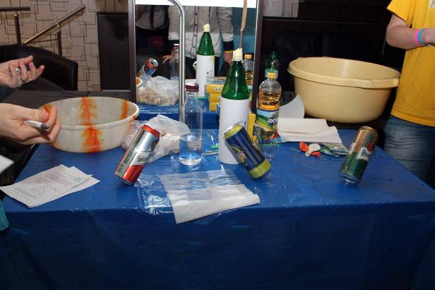 Auf einem blauen Tisch stehen Getränke, Schüsseln und andere Gegenstände.