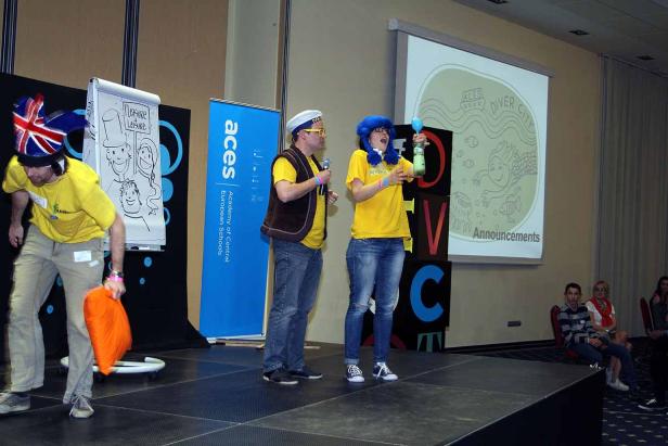 Drei Personen stehen auf einer Bühne während einer Präsentation von „ACES Diver City“.