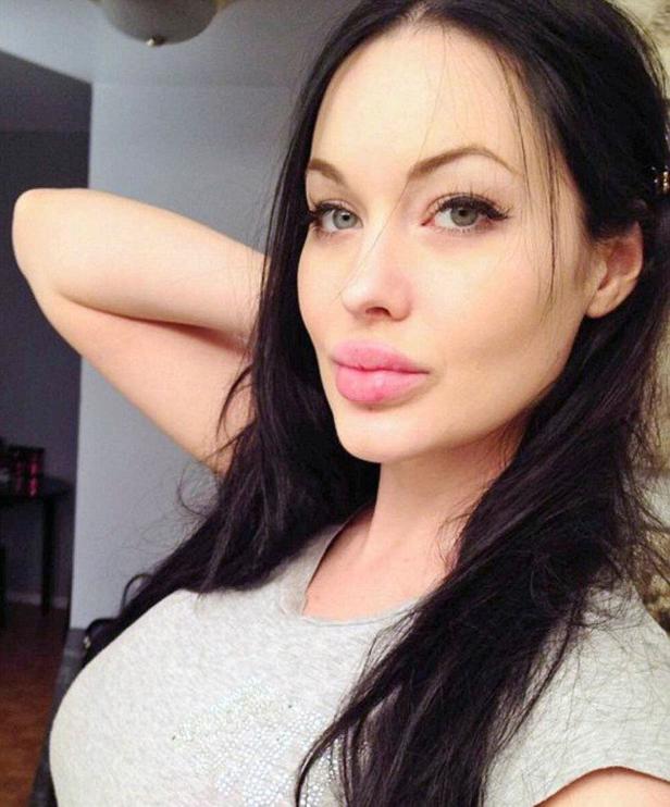 Eine Frau mit langen, dunklen Haaren und hellen Augen posiert für ein Porträt.