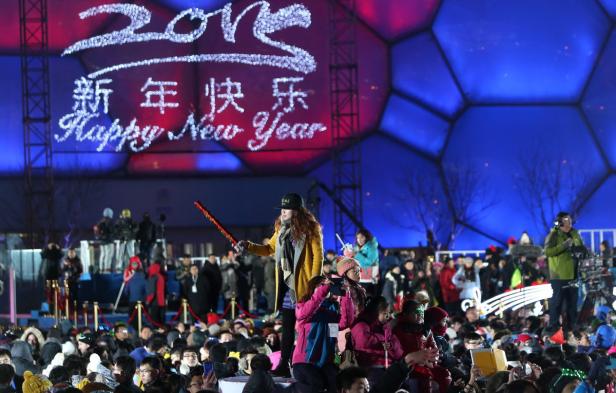 Eine Menschenmenge feiert das chinesische Neujahr vor einer Bühne mit der Aufschrift „Happy New Year“.