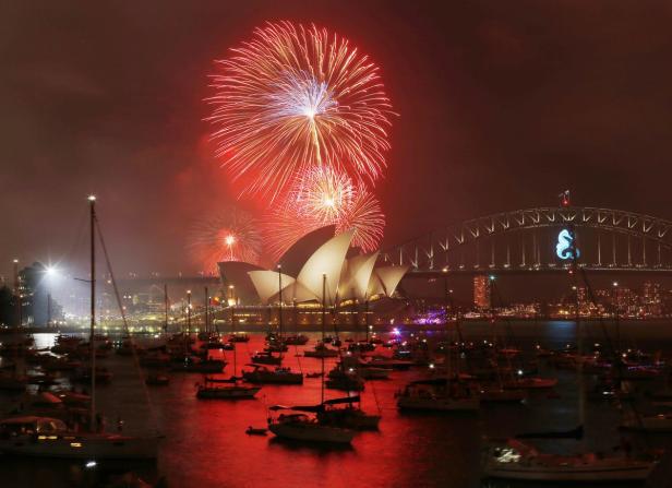 Feuerwerk über dem Hafen von Sydney mit Opernhaus und Harbour Bridge im Hintergrund.