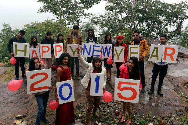 Eine Gruppe von Leuten hält Schilder mit der Aufschrift „Happy New Year 2015“.