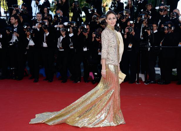 Olivia Palermo posiert auf dem roten Teppich vor einer Wand von Fotografen.