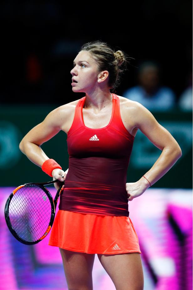 Simona Halep während eines Tennisspiels in roter Sportbekleidung.