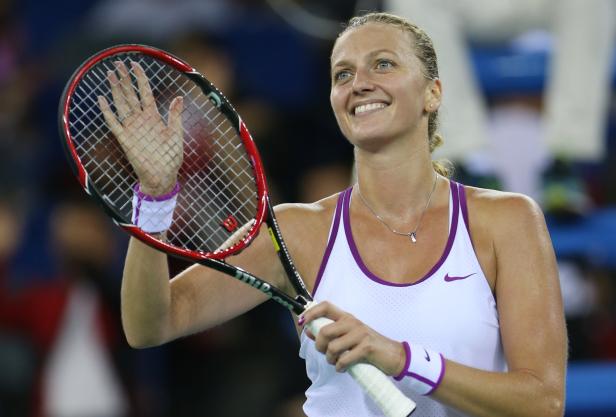 Petra Kvitová lächelt und winkt mit ihrem Tennisschläger.
