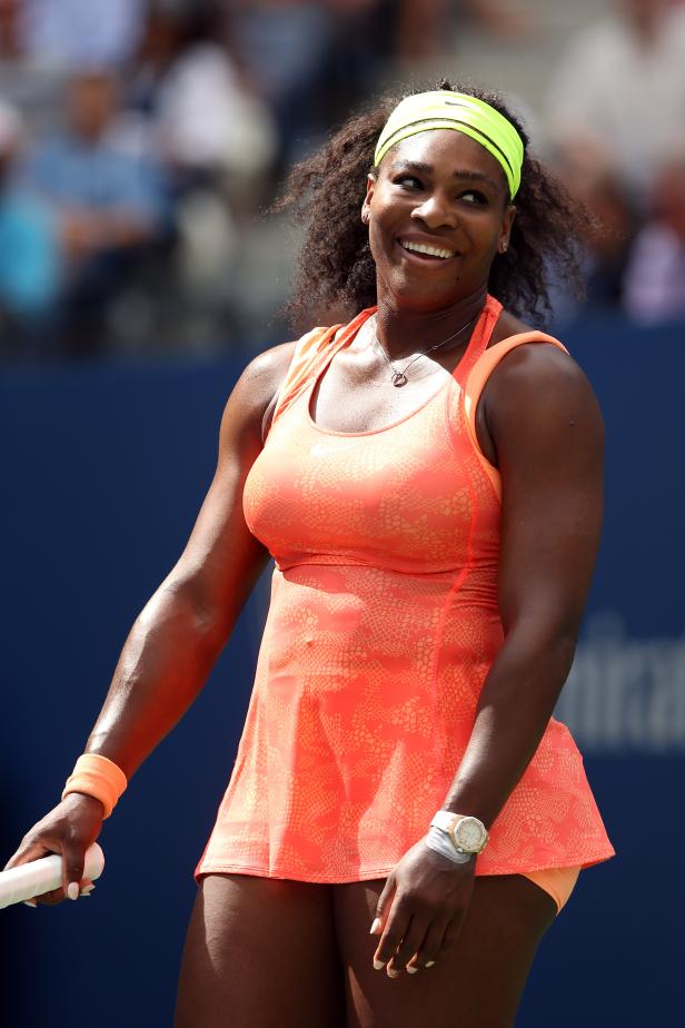 Serena Williams lächelt auf einem Tennisplatz.