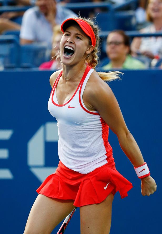 Eine Tennisspielerin jubelt auf dem Platz mit geballter Faust und offenem Mund.
