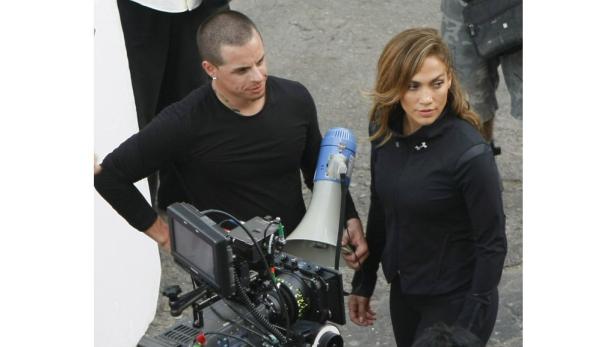 Jennifer Lopez steht mit einem Kameramann am Set.