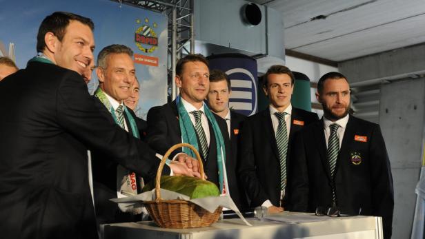 Eine Gruppe von Männern in Anzügen steht hinter einem Tisch mit einem Brotkorb.