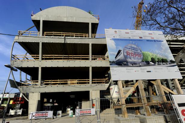 Die Baustelle des Allianz Stadions in Wien mit einem Bauschild im Vordergrund.