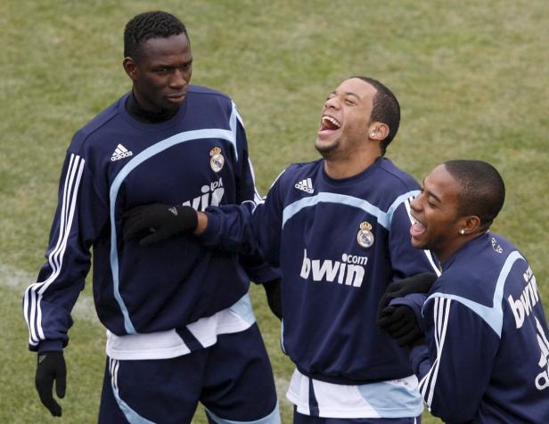 Drei Fußballspieler von Real Madrid lachen zusammen auf dem Trainingsplatz.