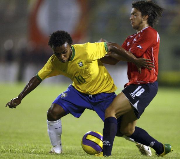 Zwei Fußballspieler kämpfen um den Ball auf dem Spielfeld.
