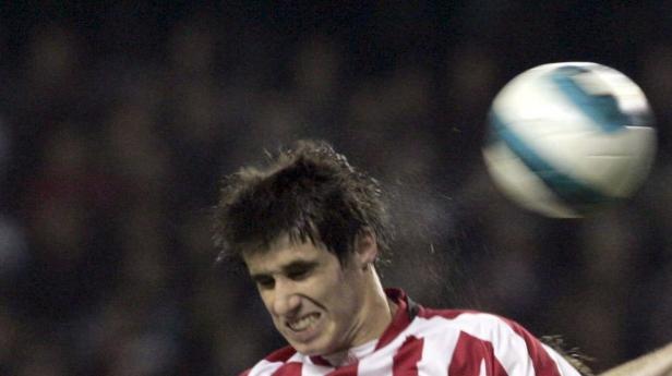 Ein Fußballspieler köpft einen Ball während eines Spiels.