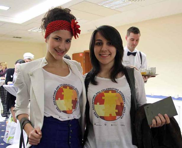 Zwei junge Frauen tragen T-Shirts mit dem Aufdruck „Accepting and Celebrating Diversity“.