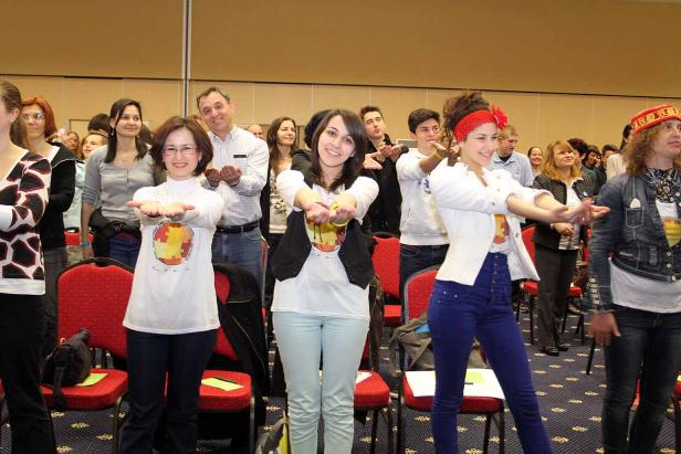 Eine Gruppe von Menschen steht in einem Raum und streckt die Hände aus.