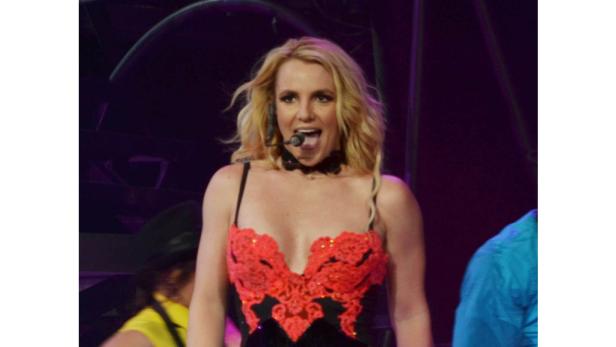 Britney Spears tritt in einem roten und schwarzen Bühnenkostüm auf.