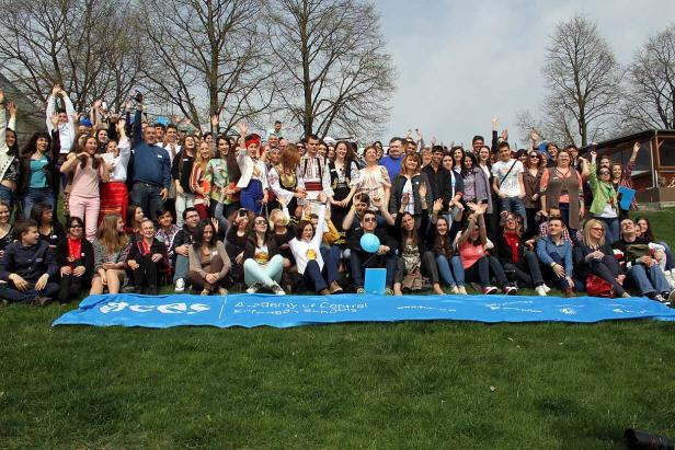 Eine große Gruppe von Menschen posiert auf einer Wiese für ein Gruppenfoto.