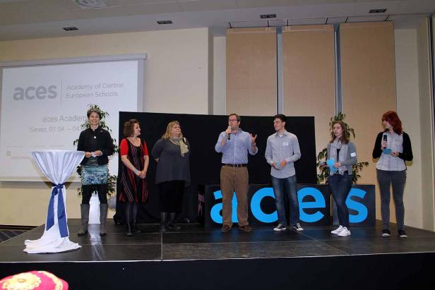 Eine Gruppe von Personen steht auf einer Bühne bei einer Veranstaltung der „Academy of Central European Schools“.