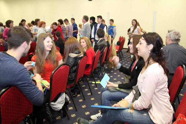 Eine Gruppe von Menschen sitzt in einem Raum und unterhält sich angeregt.