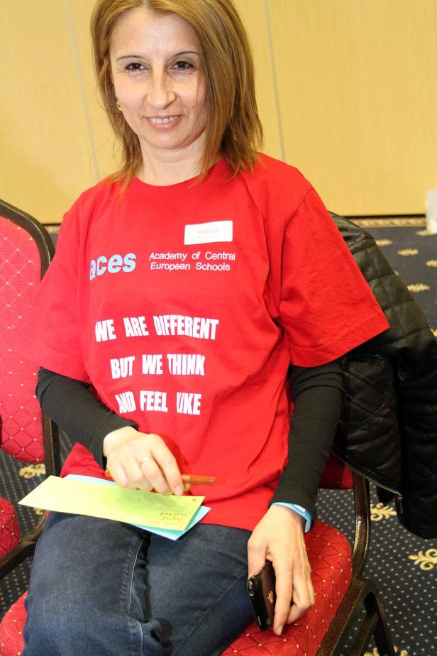 Eine Frau namens Katya trägt ein rotes T-Shirt mit der Aufschrift „We are different but we think and feel alike“.