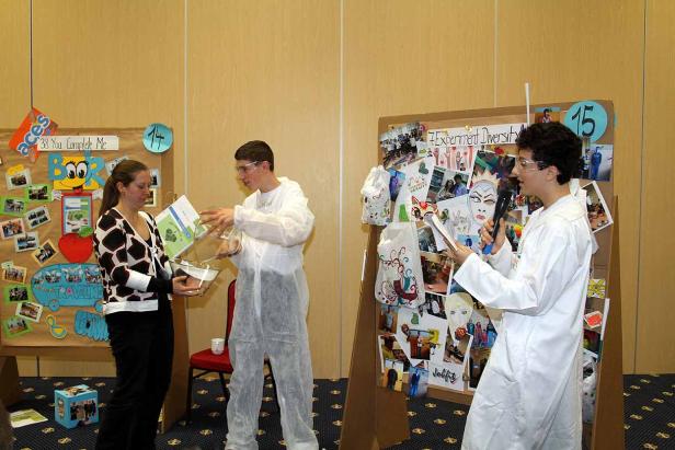 Zwei Schüler präsentieren ihre wissenschaftlichen Projekte vor Stellwänden.