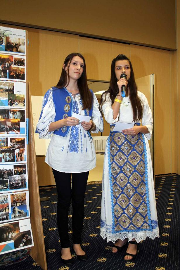 Zwei junge Frauen in traditioneller Kleidung halten Reden.