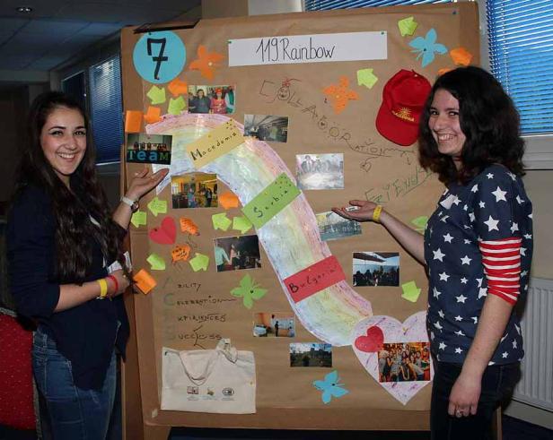 Zwei junge Frauen präsentieren eine Collage mit dem Titel „119 Rainbow“.