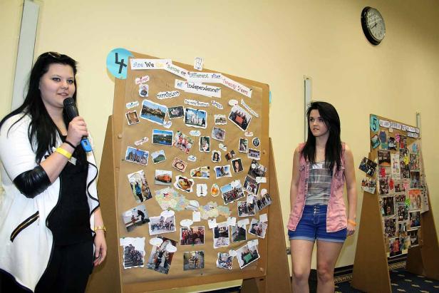 Zwei junge Frauen präsentieren eine Collage zum Thema Unabhängigkeit.