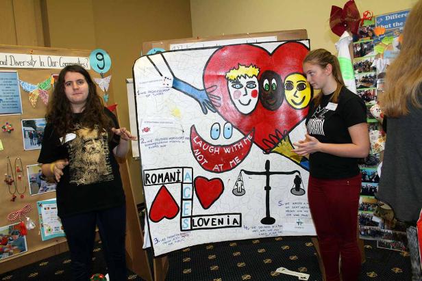 Zwei junge Frauen präsentieren ein Projekt über Vielfalt mit Zeichnungen und Texten.