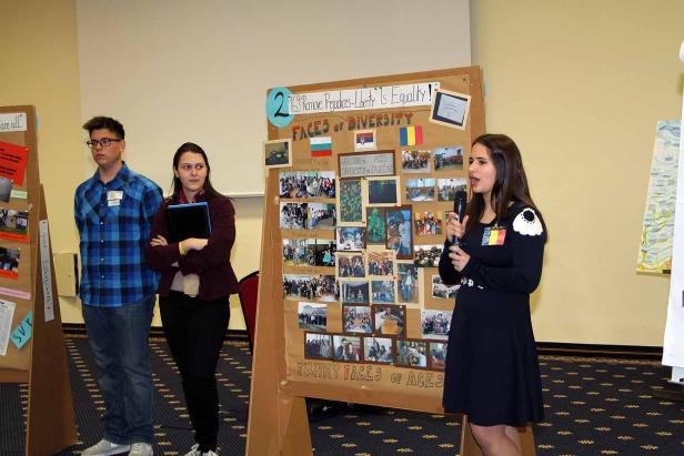 Eine junge Frau präsentiert ein Projekt über Vielfalt vor Publikum.