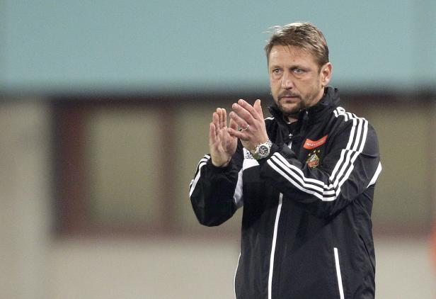 Ein Mann in einer schwarzen Jacke klatscht in die Hände.