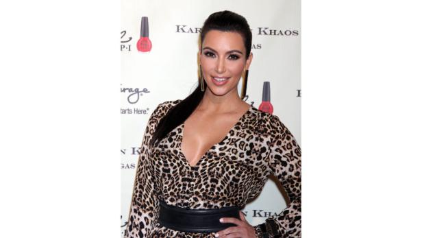 Kim Kardashian in einem Leopardenkleid bei einer Veranstaltung.