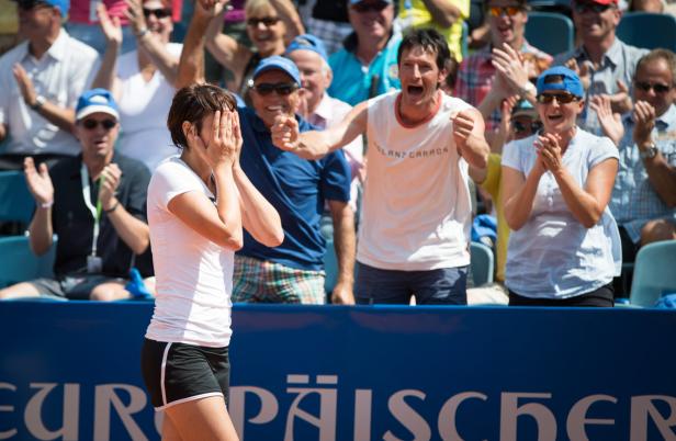 Eine Tennisspielerin verdeckt ihr Gesicht, während das Publikum jubelt.
