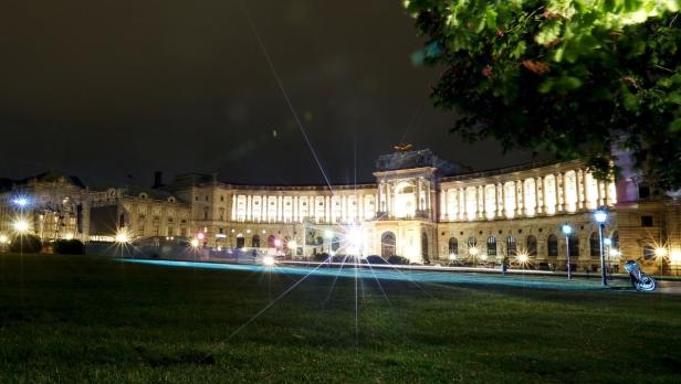 Die Hofburg in Wien erstrahlt nachts im hellen Licht.