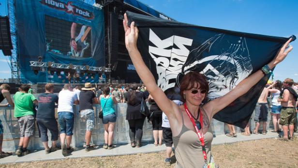 Eine Frau hält eine Flagge der Band Royal Republic auf dem Nova Rock Festival.