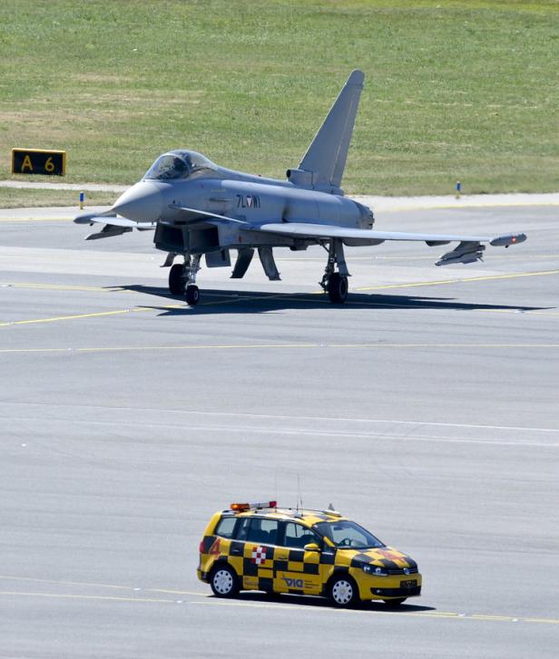 Ein Eurofighter des österreichischen Bundesheeres steht auf einem Flugfeld, im Vordergrund ein gelbes Lotsenfahrzeug.
