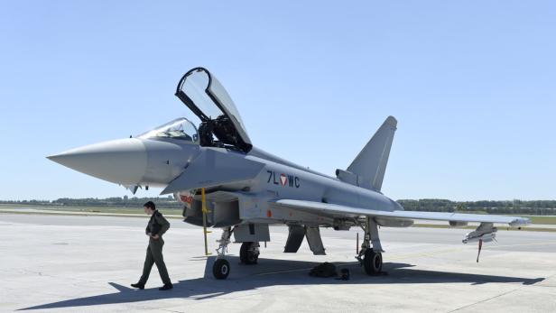 Ein Eurofighter des österreichischen Bundesheeres steht auf einem Flugfeld, ein Pilot geht vorbei.