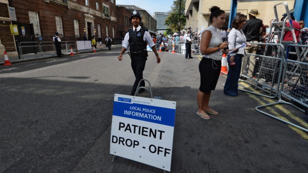 Ein Polizist geht an einem Schild mit der Aufschrift „Patient Drop-Off“ vorbei.