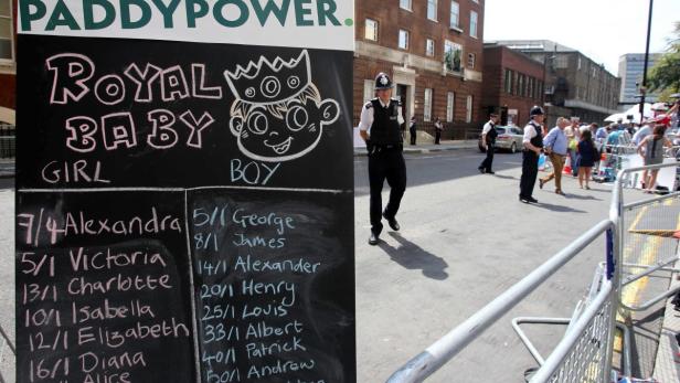 Ein Paddy Power-Schild mit Vorhersagen für das Geschlecht des königlichen Babys und Polizisten im Hintergrund.