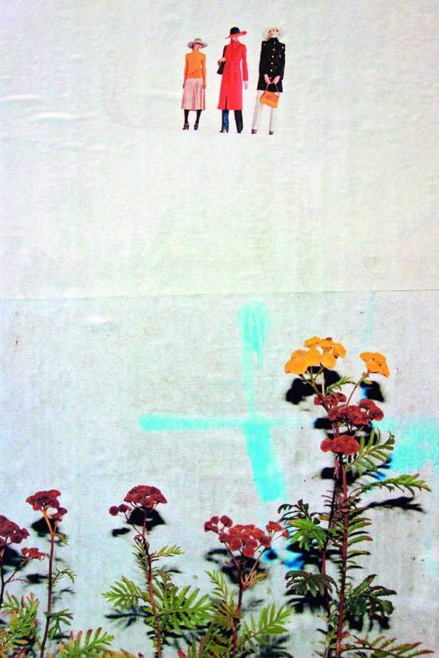 Drei Frauen in modischen Mänteln stehen vor einer Wand mit Blumenmalereien.